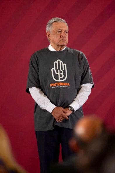 AMLO cumpliendo una promesa a los padres de los 43, portando una playera del caso Ayotzinapa.