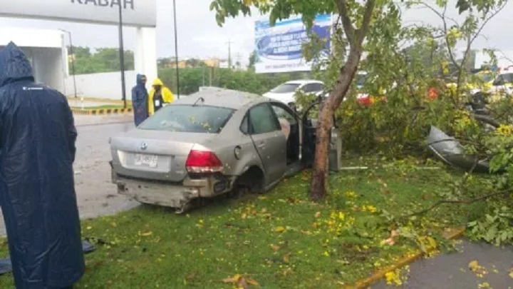 Cancún: Choca y derriba poste y un árbol en la avenida Kabah; conductor pierde el control por el exceso de velocidad y ´pavimento mojado.