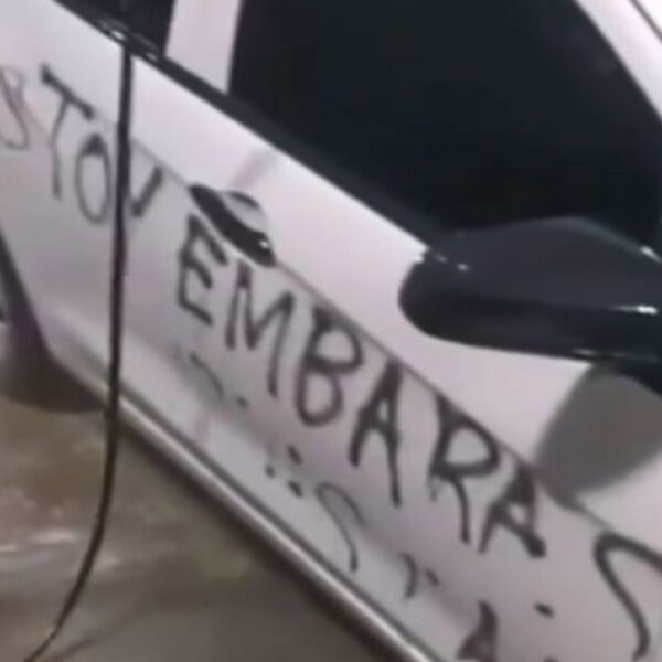 En un autolavado intentan quitarle a un coche blanco una letras negras, en las que se lee: “Estoy embarazada hazte responsable"