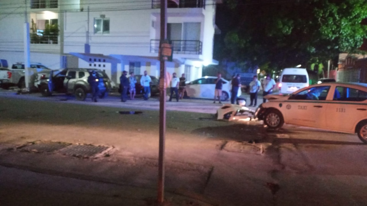Protagoniza taxista de Playa del Carmen aparatoso choque; por no respetar su alto impactó a dos vehículos y derribó una barda.