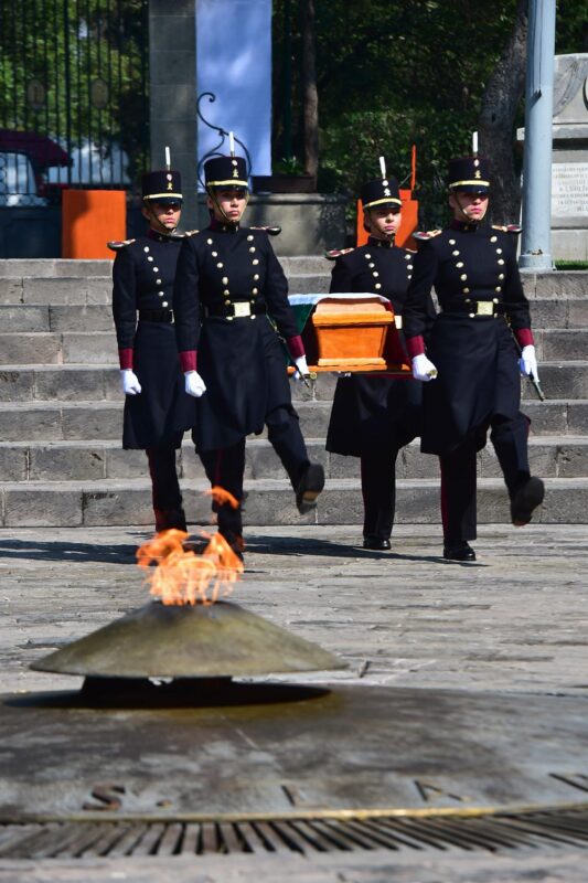 Cadetes del Heroico Colegio Militar trasladaron la urna con sus cenizas, engalanada con la bandera nacional, hasta el monumento edificado en su honor, mientras la banda de guerra de ese cuerpo entonaba la diana marcial.