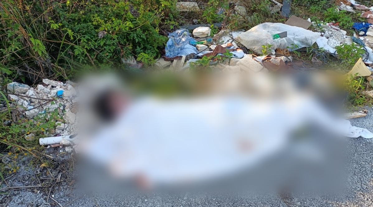 Hallan cadáver ensabanado cerca de la entrada de Real Valencia en Cancún; la víctima es un hombre joven quien tiene envuelta la cabeza.