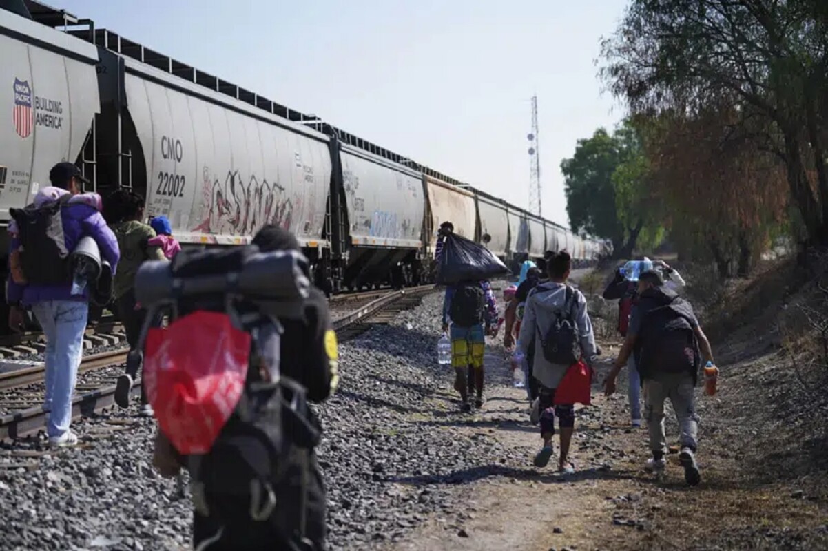 Migrantes caminan junto a un tren con dirección al norte, esperando poder subirse a él, en Huehuetoca, México, el viernes 12 de mayo de 2023. (AP Foto/Marco Ugarte)