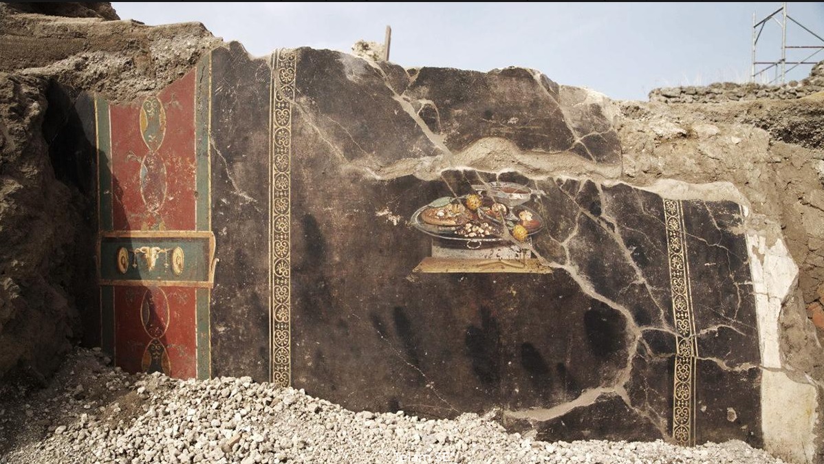 Descubren antepasado de la pizza en una pintura en ruinas de Pompeya; el fresco fue descubierto en el atrio de una casa adyacente a una panadería.