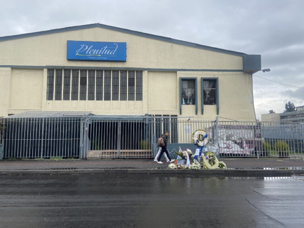Unas flores colocadas en el lugar donde fue asesinado el 9 de agosto el candidato presidencial Fernando Villavicencio, en la Avenida Gaspar Villarroel, en una lluviosa Quito, simbolizan el ambiente en que los ecuatorianos van a las urnas el domingo 20. Imagen: Carolina Loa / IPS