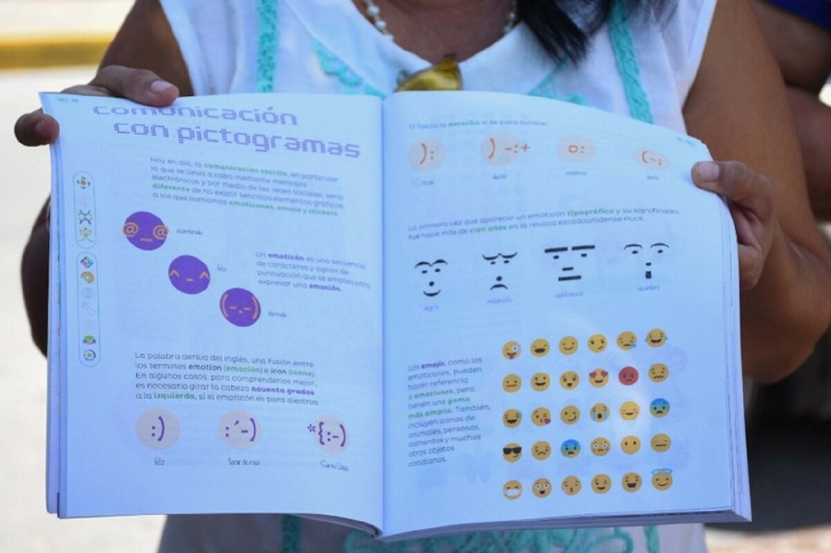 Una mujer muestra dos páginas del nuevo libro de matemáticas de tercer grado como parte de una protesta contra el material de la SEP.