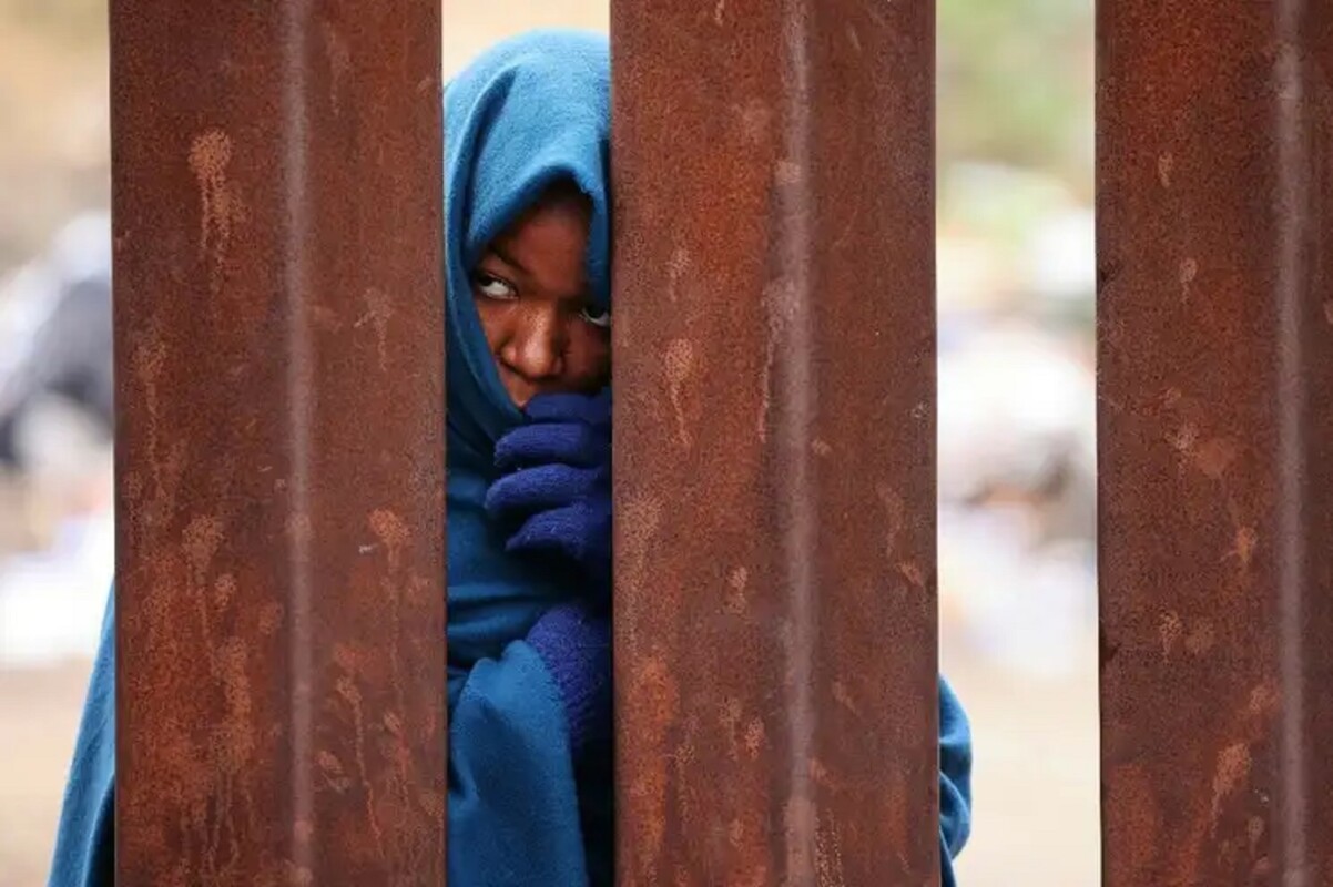 En la imagen, una mujer de Camerún espera tras el muro entre Tijuana, Baja California, y San Diego, California.
