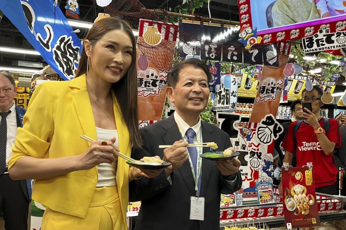 El ministro de Agricultura de Japón, Ichiro Miyashita, a la derecha, y la celebridad malasia Amber Chia asisten a un evento en una tienda japonesa Don Don Donki, en Kuala Lumpur, el miércoles 4 de octubre de 2023, para promover la seguridad y exquisitez de los ostiones japoneses entre los consumidores. (AP Foto/Eileen Ng)