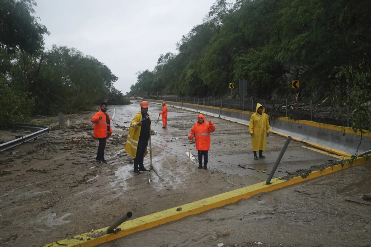 Trabajadores de la Secretaría de Infraestructura, Comunicaciones y Transportes limpian la Autopista del Sol tras el paso del huracán Otis.