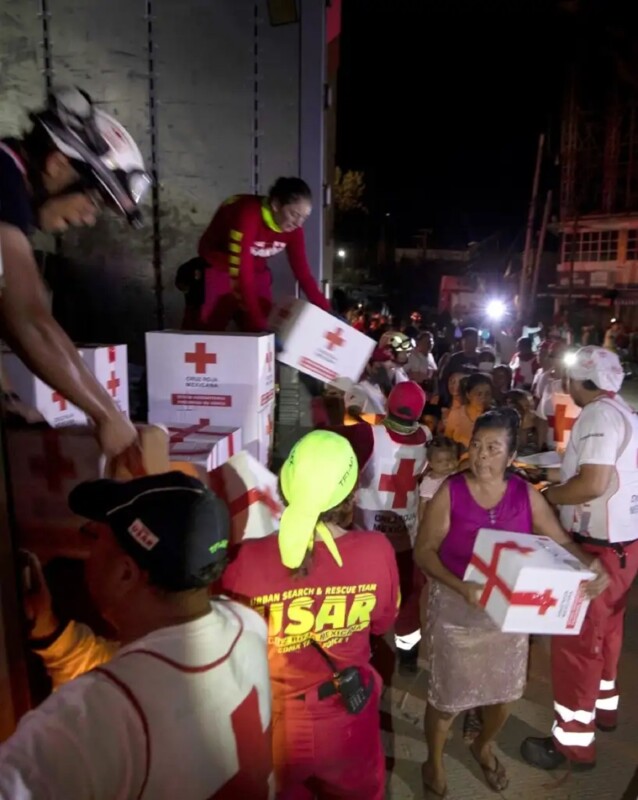 Miembros de la Benemérita Cruz Roja entregan despensas a damnificados en Acapulco.