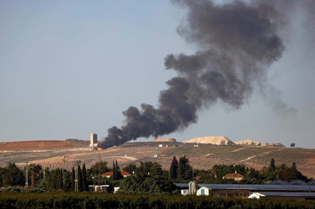 Fotografía tomada desde el lado israelí de la frontera, que muestra llamas y humo después de un bombardeo, al sur de la franja de Gaza.