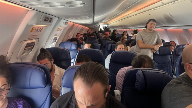 Pasajero abre la puerta y camina por el ala de avión en el AICM