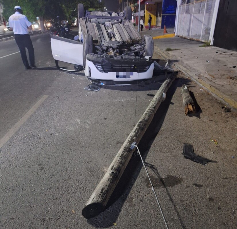 Automovilista termina volcado en la avenida Nichupté de Cancún; pierde el control del volante y choca contra dos postes que derribó.