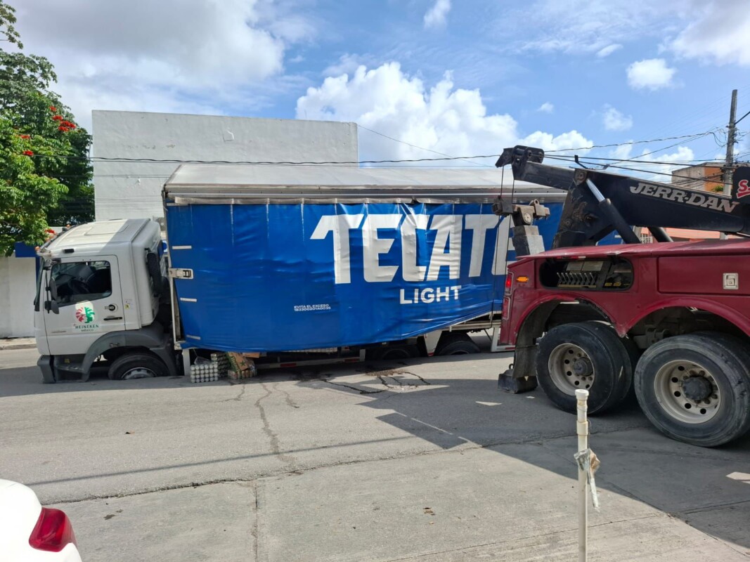 Camión se hunde en socavón cerca del sindicato taxista en Cancún; la unidad de carga estuvo a punto de volcar sobre su costado izquierdo en calle 71.