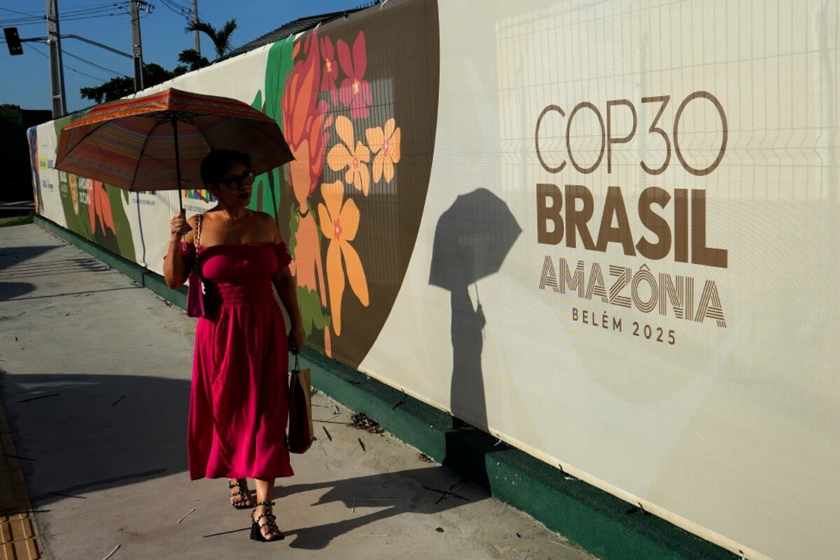 Una mujer pasa por delante de un cartel de la cumbre del clima de Naciones Unidas, COP30, en Belém, en el estado de Pará, Brasil, el 4 de noviembre de 2025. (AP Foto/Eraldo Peres)