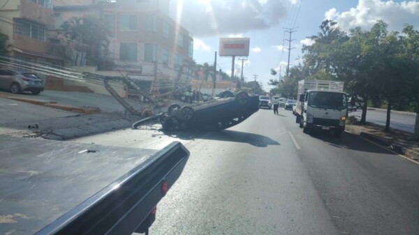 Vuelca un auto y derriba un poste sobre la avenida Kabah