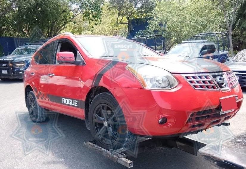 La camioneta Nissan, modelo Rogue, color rojo que fue recuperada por la Policía Municipal en la Supermanzana 245 de Cancún.