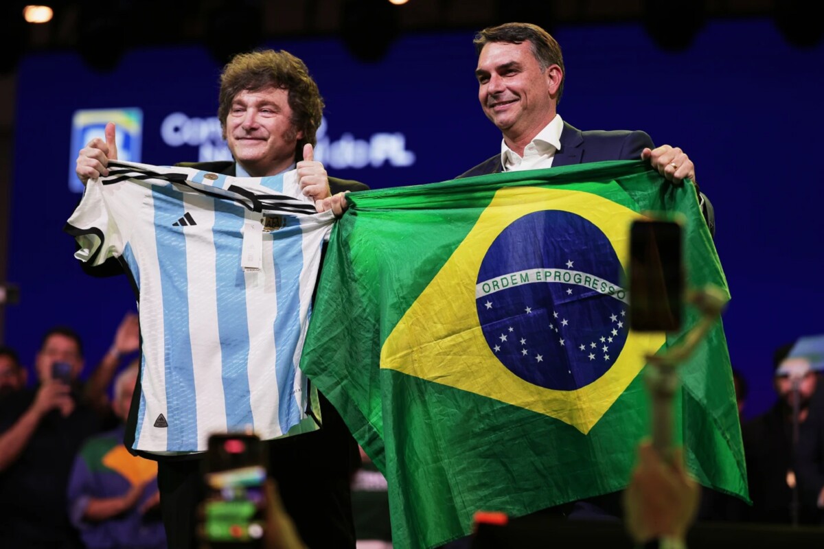 El senador brasileño Flavio Bolsonaro sostiene una bandera de Brasil mientras el presidente argentino Javier Milei hace lo propio con una camiseta de la selección argentina de fútbol, durante la convención del Partido Liberal, en la que se confirmó a Bolsonaro para que sea el candidato presidencial del partido, el sábado 25 de julio de 2026, en Sao Paulo, Brasil. 
