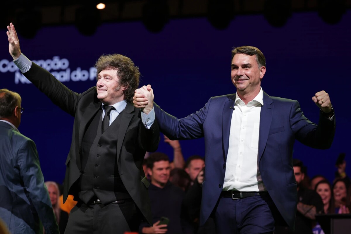 El senador brasileño Flavio Bolsonaro, a la derecha, y el presidente argentino Javier Milei saludan a sus simpatizantes durante la convención del Partido Liberal, en la que Bolsonaro fue confirmado como su candidato presidencial.