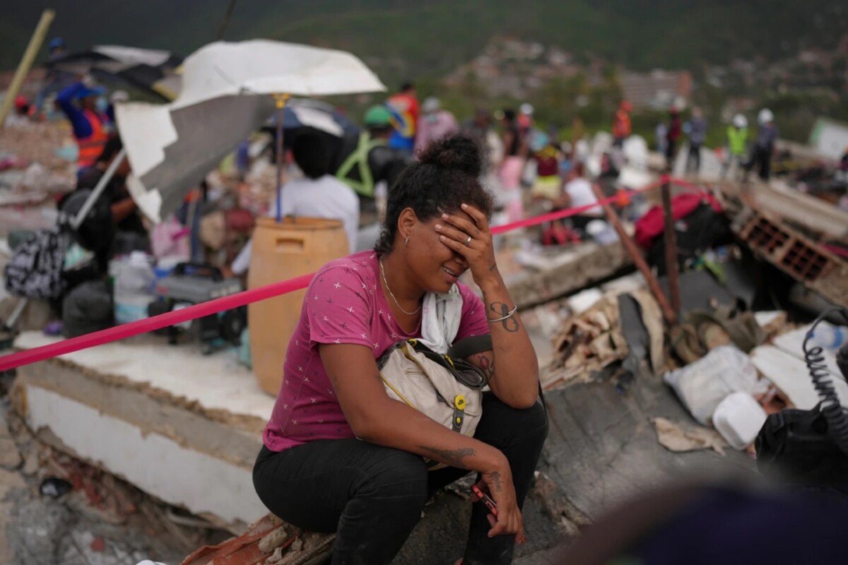 Khaterine Roa llora mientras miembros del Departamento de Bomberos del Condado de Los Ángeles buscan sobrevivientes en un edificio que se derrumbó durante los terremotos que azotaron La Guaira, Venezuela, el martes 30 de junio de 2026. 