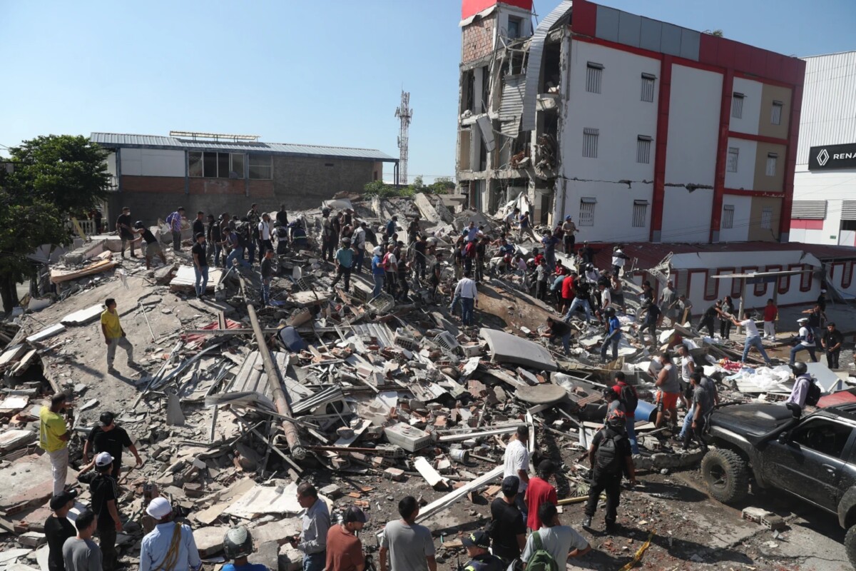 Residentes y equipos de rescate buscan entre los escombros de un edificio derrumbado tras el terremoto que azotó Cali, Colombia.