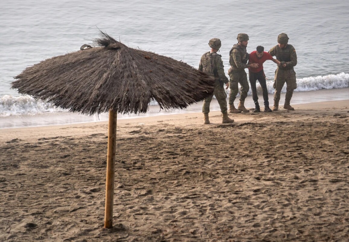 Soldados del ejército español ayudan a una persona que llegó a nado al enclave español de Ceuta, en el norte de África, desde Marruecos, el 1 de agosto de 2026.  