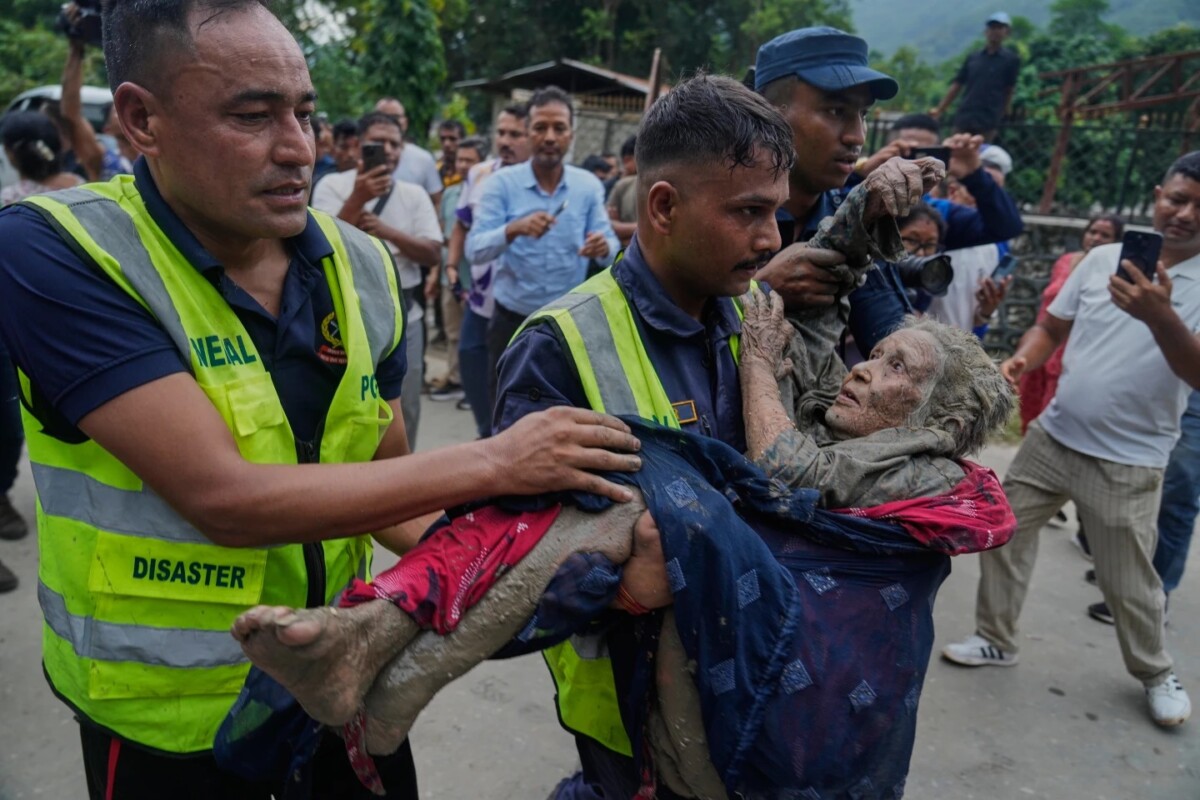Rescatistas trasladan a una víctima de las inundaciones repentinas a un lugar seguro a orillas del río Trishuli, en el distrito de Nuwakot, Nepal. 