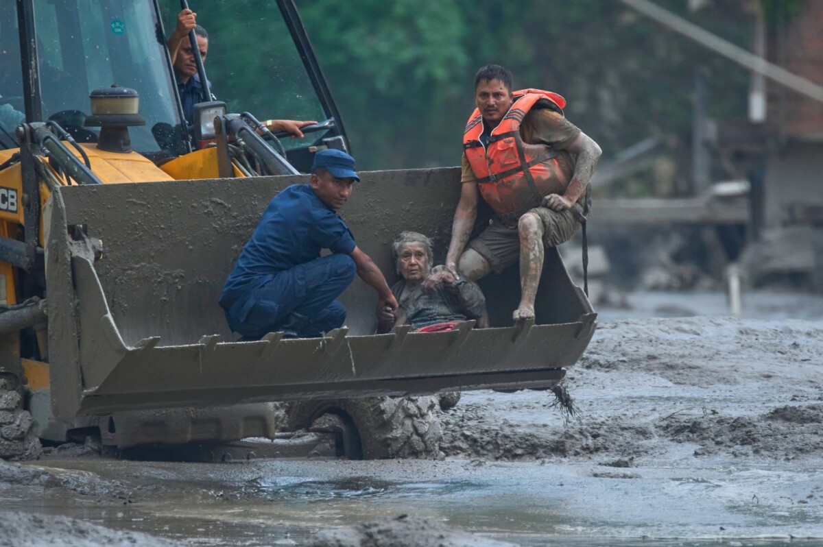 Rescatistas usan una excavadora para poner a salvo a las víctimas de una inundación a lo largo del río Trishuli, en el distrito de Nuwakot, Nepal. 